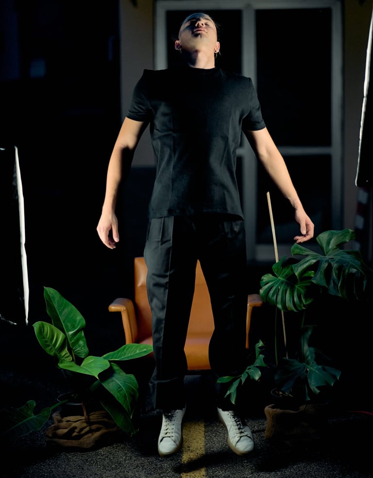 a man in a black shirt and white sneakers