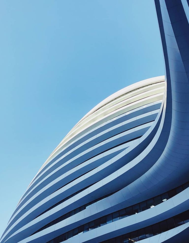 a building with a large curved building in the background