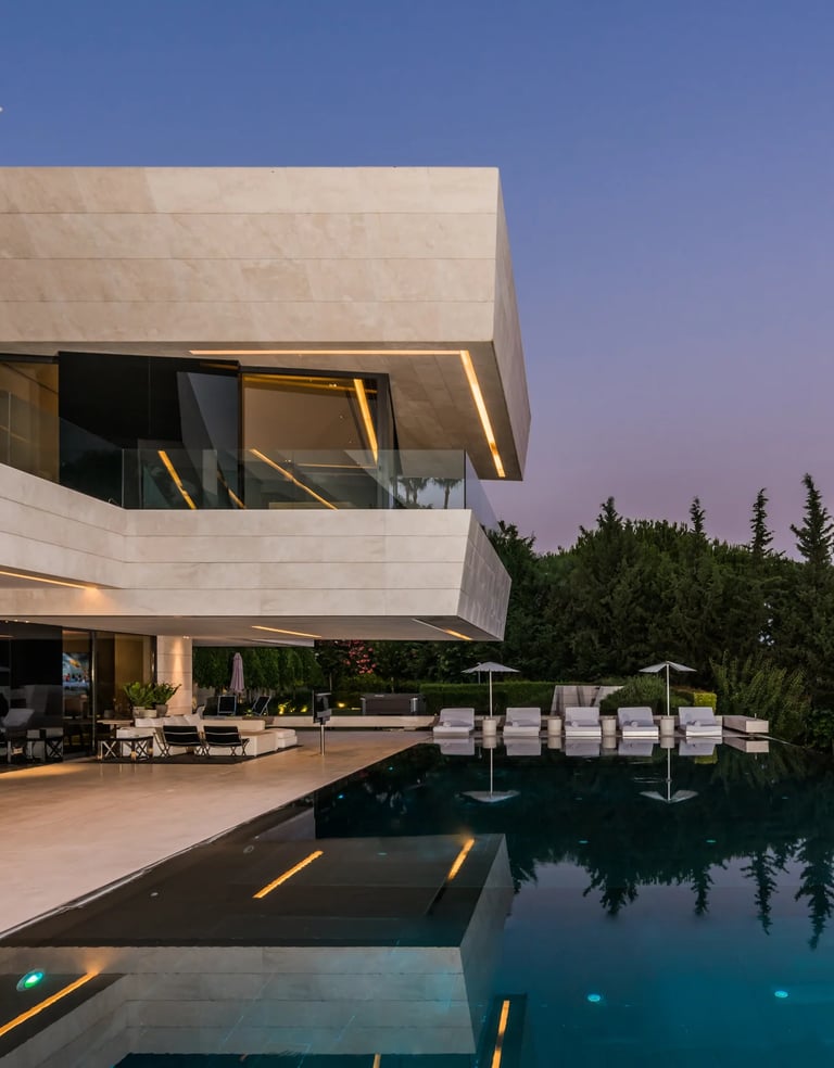 Dusk terrace with illuminated pool and glass façade