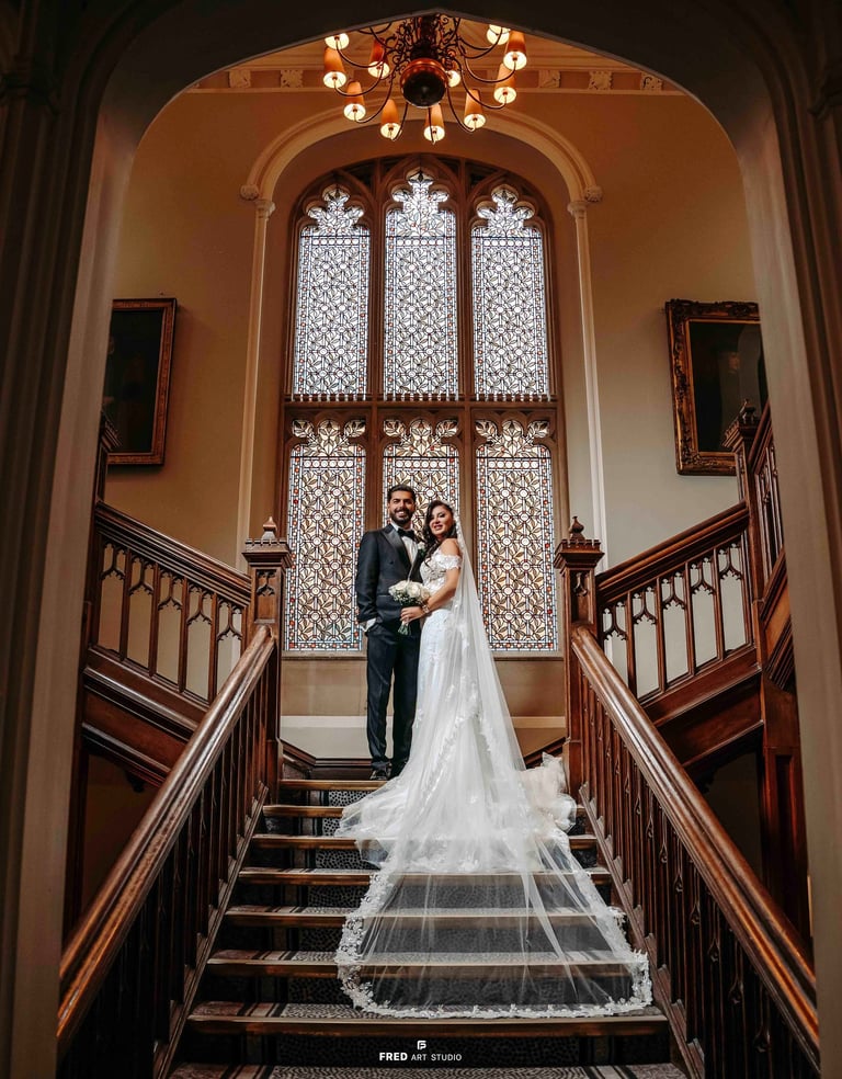 Bride and groom standing on grand staircase – Oxford wedding photo by Fred Art Studio