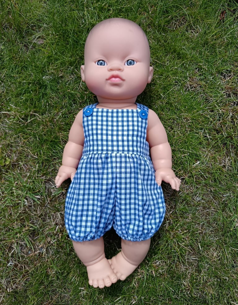 Minikane doll Rai dressed in blue gingham overalls