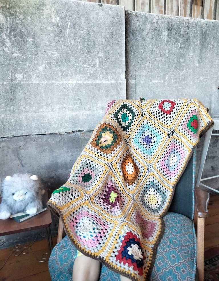 a person sitting in a chair with a blanket on it