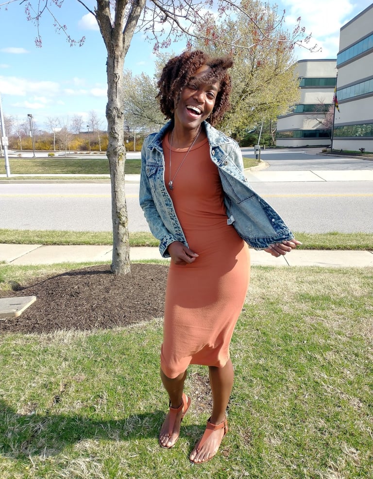 woman in brown dress and jeans jacket smiling. welcome to my blog!