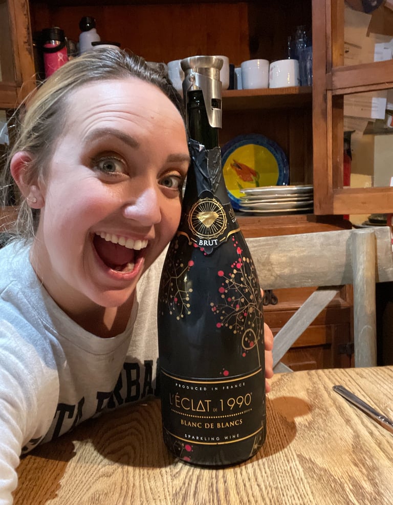 Danielle, 12/31/2022 hugging a Trader Joe's bottle of L'Eclat sparkling wine.