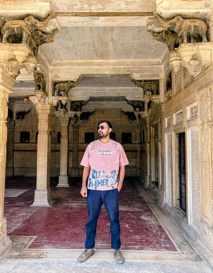 Traveler posing gracefully between the elephant columns of Baradari at Chhatar Mahal, Bundi, capturing the charm of royal-era