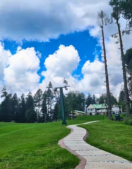 a path leading to a grassy field with a path leading to a house at greenspot nathiagali