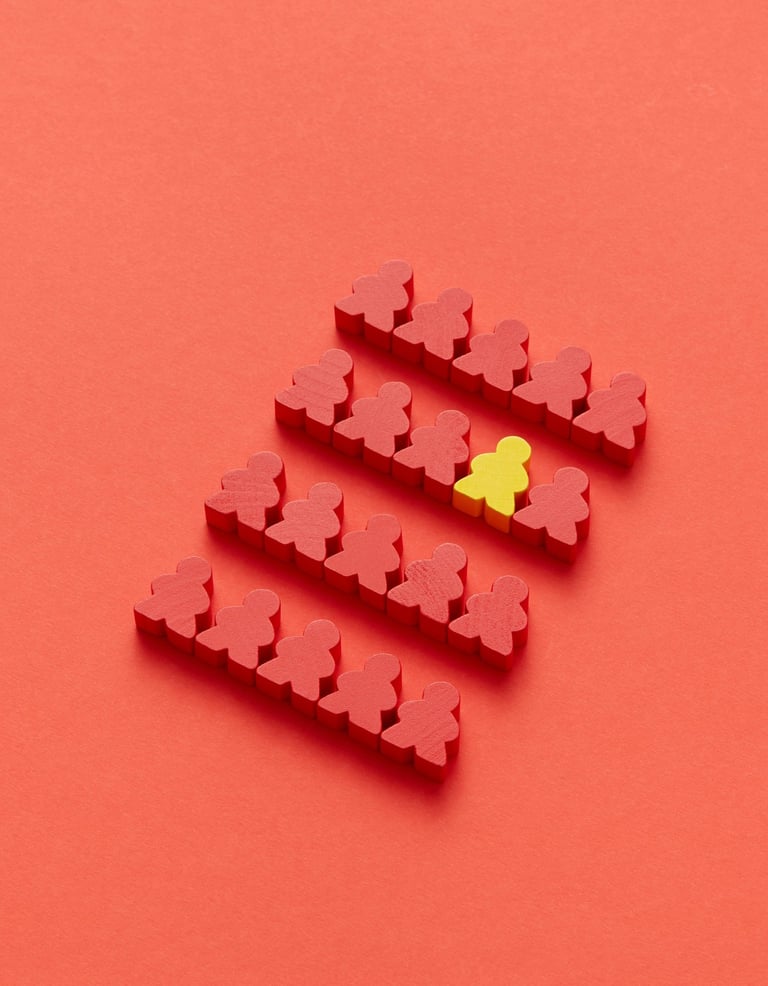 Rode poppetjes met één geel ertussen, symboliseert kwetsbaarheid, verschil en inclusie in beleid.