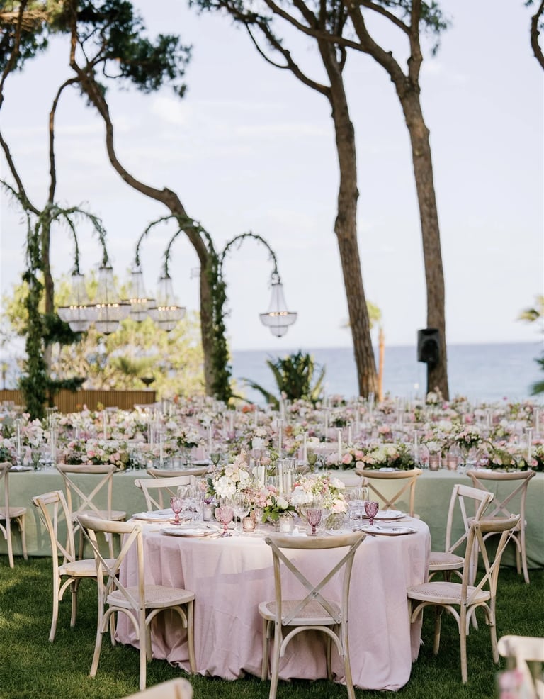Seafront garden event layout with chandeliers and banquet tables