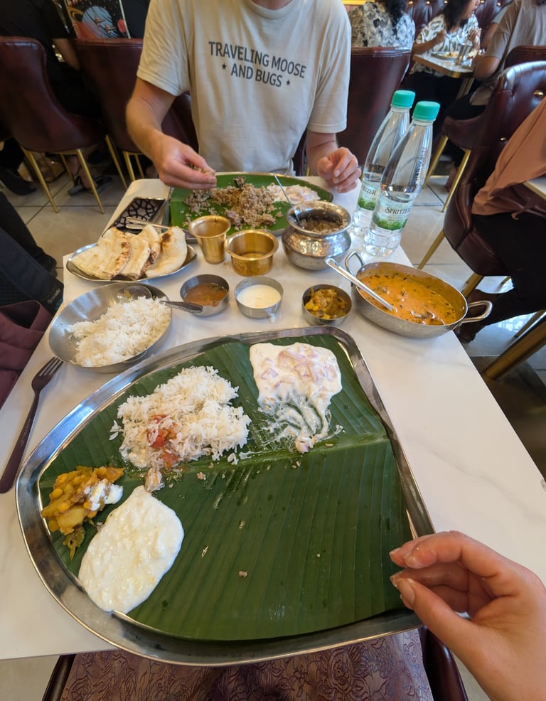 Traditional South Indian thali meal served on a banana leaf with rice, curry, and raita at Erode Amm