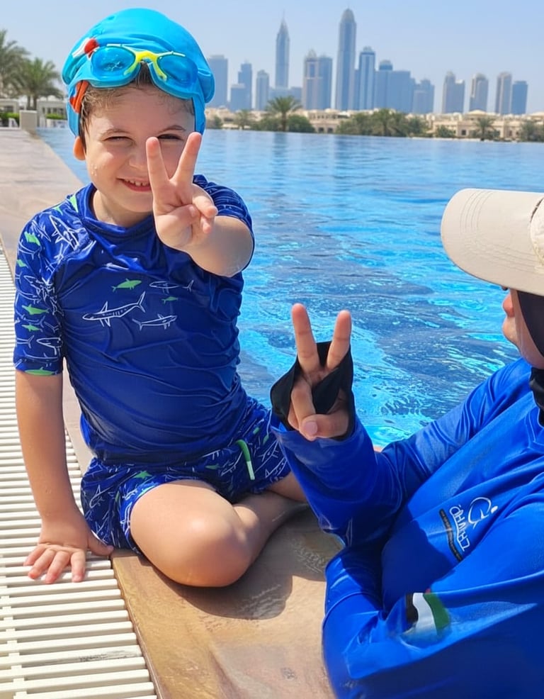 A smiling boy in blue swimwear by an infinity pool with the Dubai