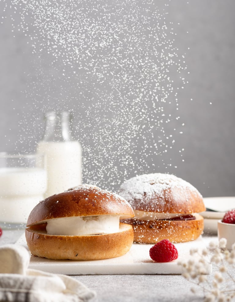 a couple of bundts with raspberries and cream and flying sugar powder