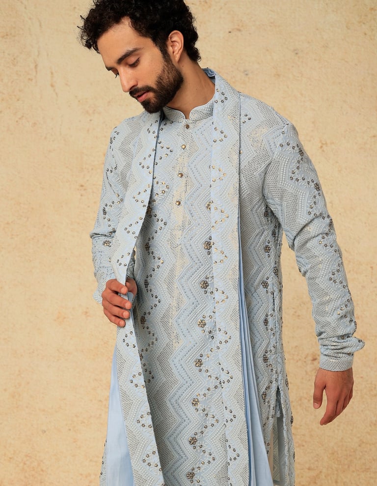 a man in a blue and white indian wedding suit