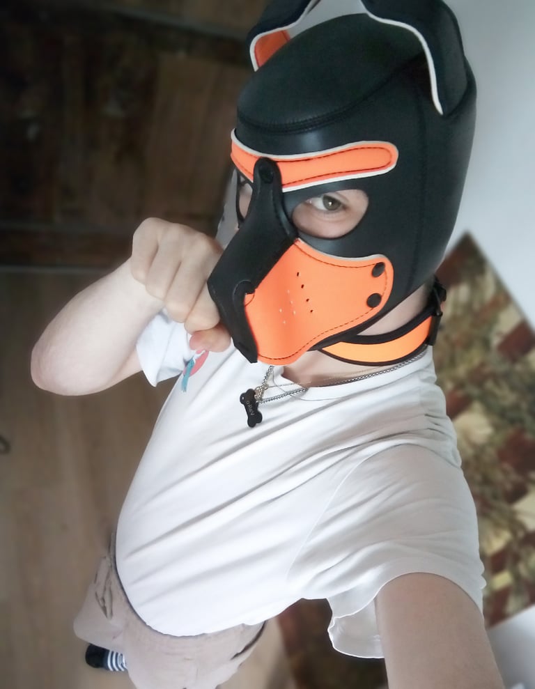 Man poses for a selfie in a pup mask.