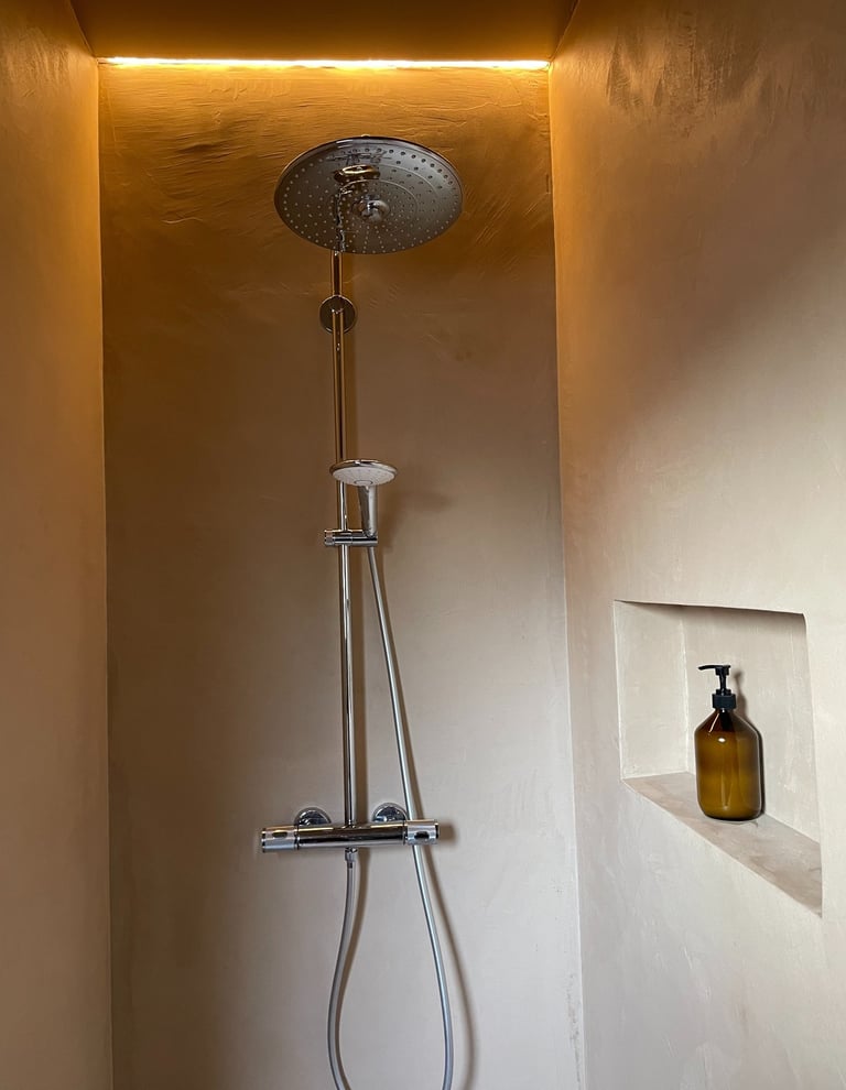 Inloopdouche met ronde regendouche, handdouche en nis in beige wand