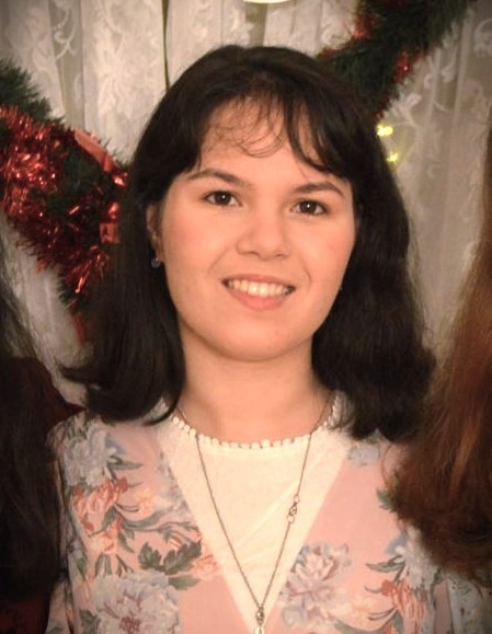a woman in a floral dress smiling for the camera