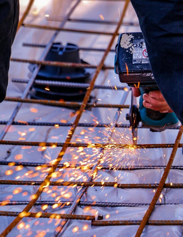 Découpe de barres d’armature métallique avec une meuleuse pour le ferraillage d’une dalle en béton