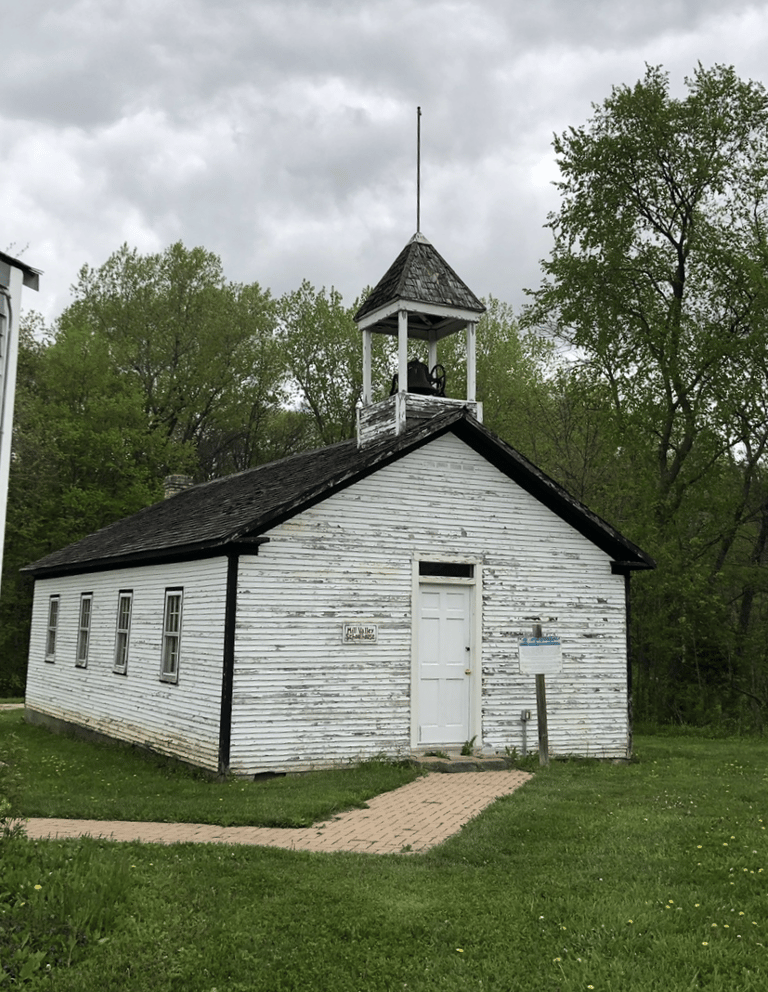 A white wooden church with a bell