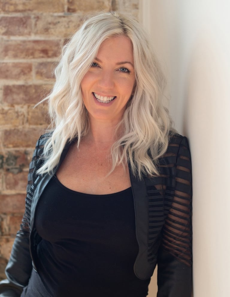 Headshot of artist and photographer Tanya Smith of Sweet Ruby Moon on brick wall