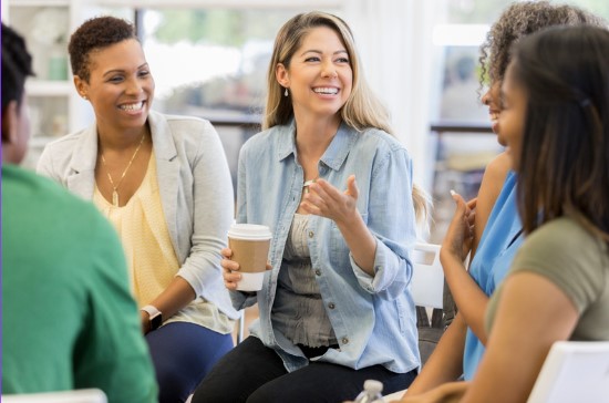 a group of people sitting around a table with coffee cups