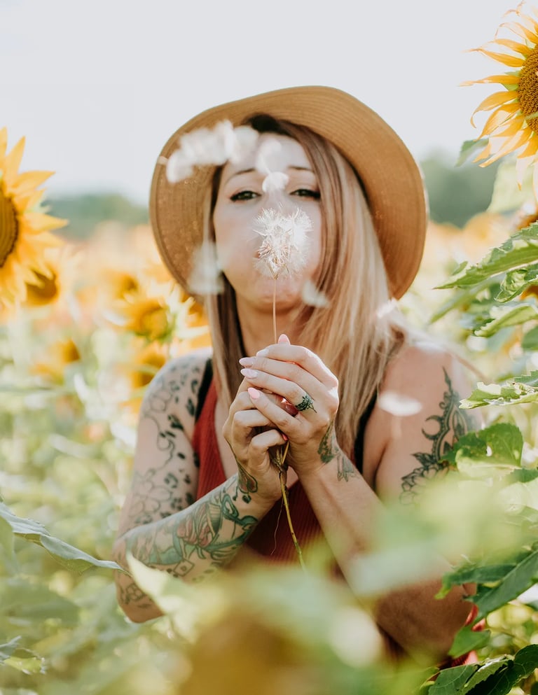 une femme souffle sur un pissenlit