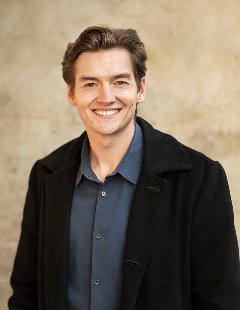 a man in a black jacket and a blue shirt