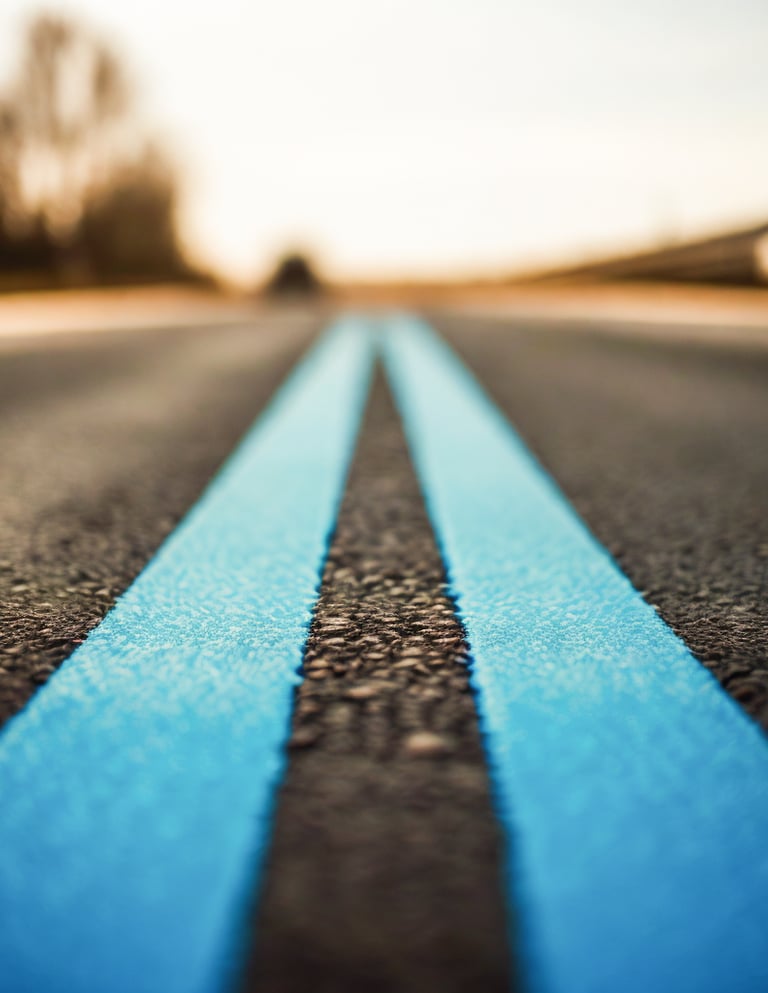 duas faixas contínuas de uma rodovia pintadas em azul claro que seguem em direção ao horizonte