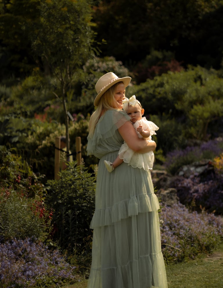 mother holding her baby on the arms in the park