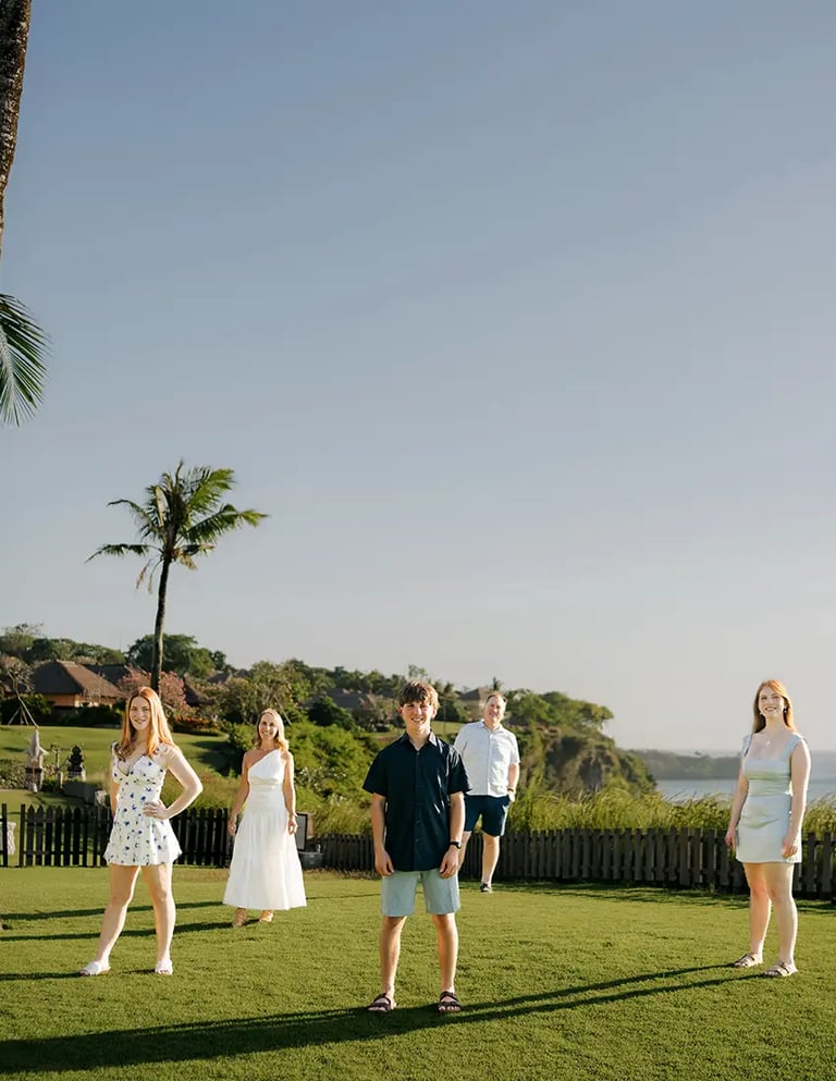 Family portrait on the oceanfront lawn during a family photography session at AYANA Resort Bali