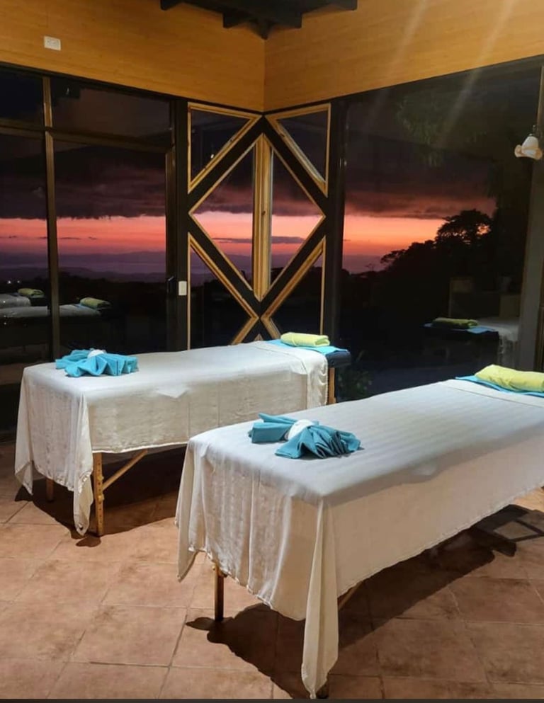 two massage beds in a room with a view of the ocean