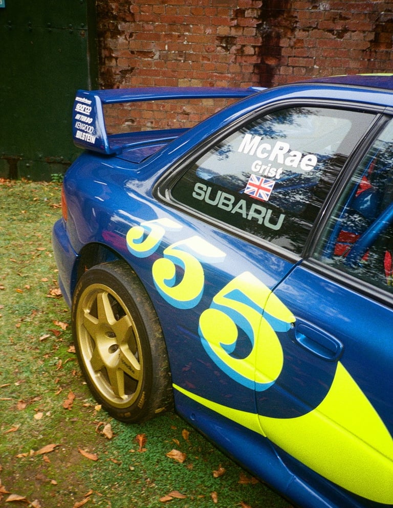 a blue and yellow Subaru Impreza rally car