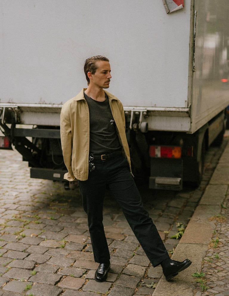 portrait of artist and designer Philipp Schäfer standing on a brick sidewalk next to a truck