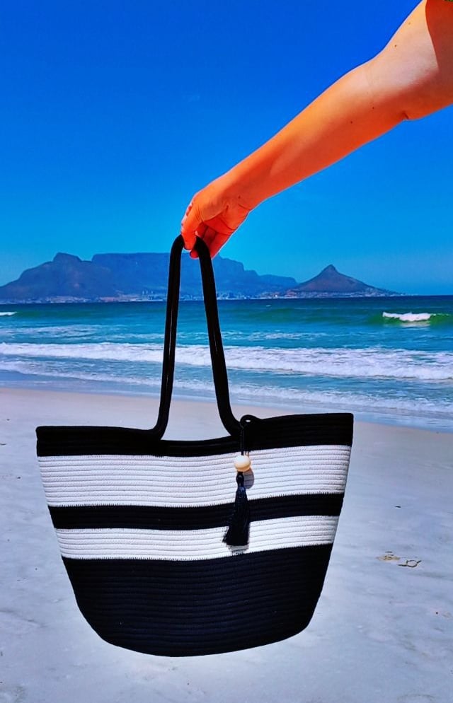 a person holding a black and white striped bag