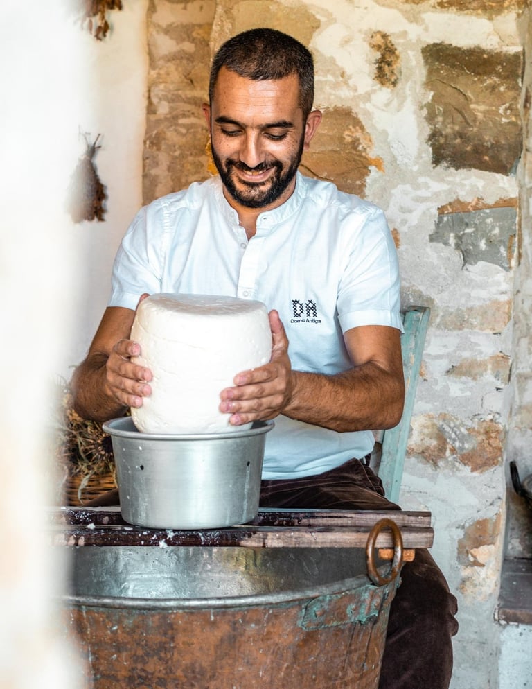 Sardinian cheesemaker shaping fresh cheese inside a traditional copper cauldron