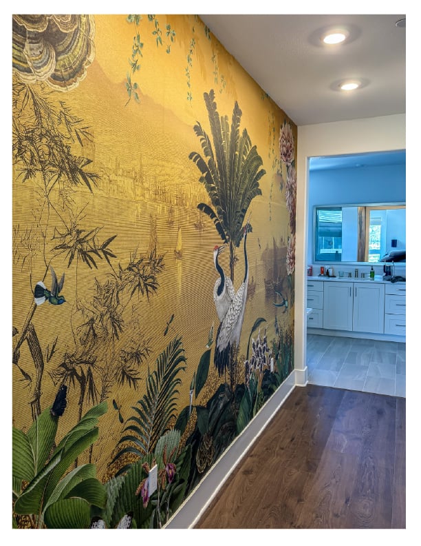 Elegant gold chinoiserie wallpaper mural with cranes and tropical plants on a hallway accent wall.