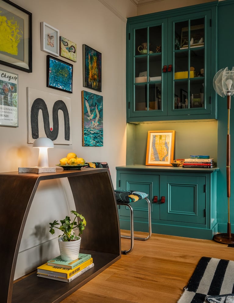 maximalist home office with gallery wall, teal storage, mid-century touches