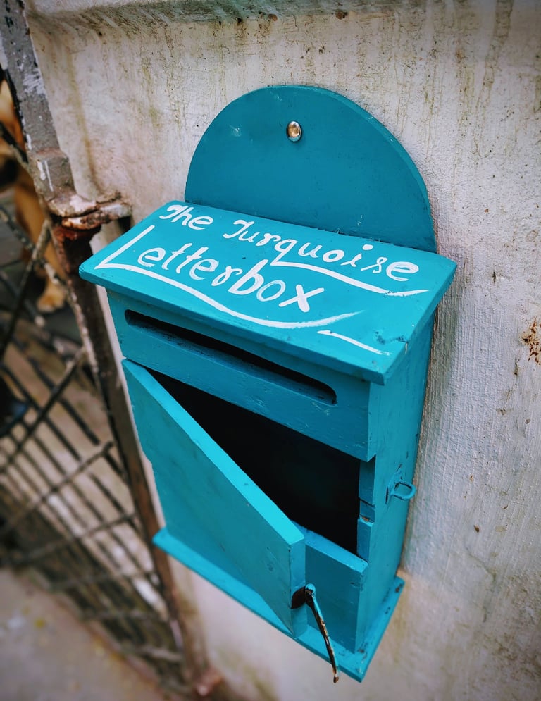 a blue mailbox with a sign that says the mailbox is a mailbox