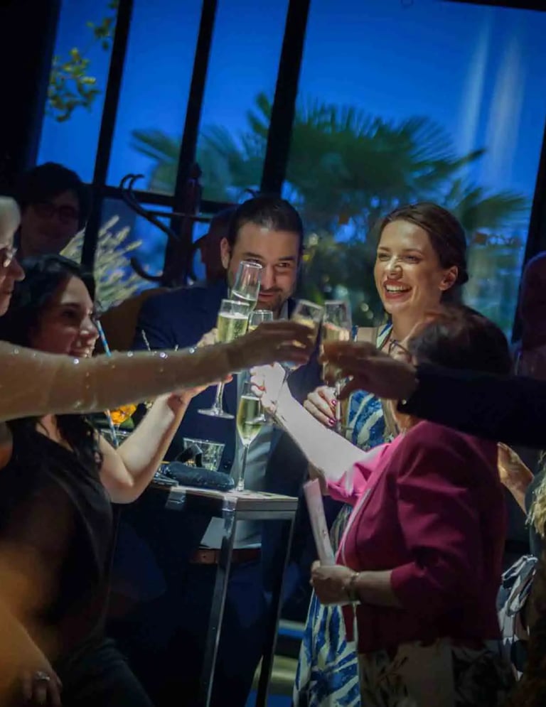 Friends making a celebratory toast with champagne glasses at an evening party event.