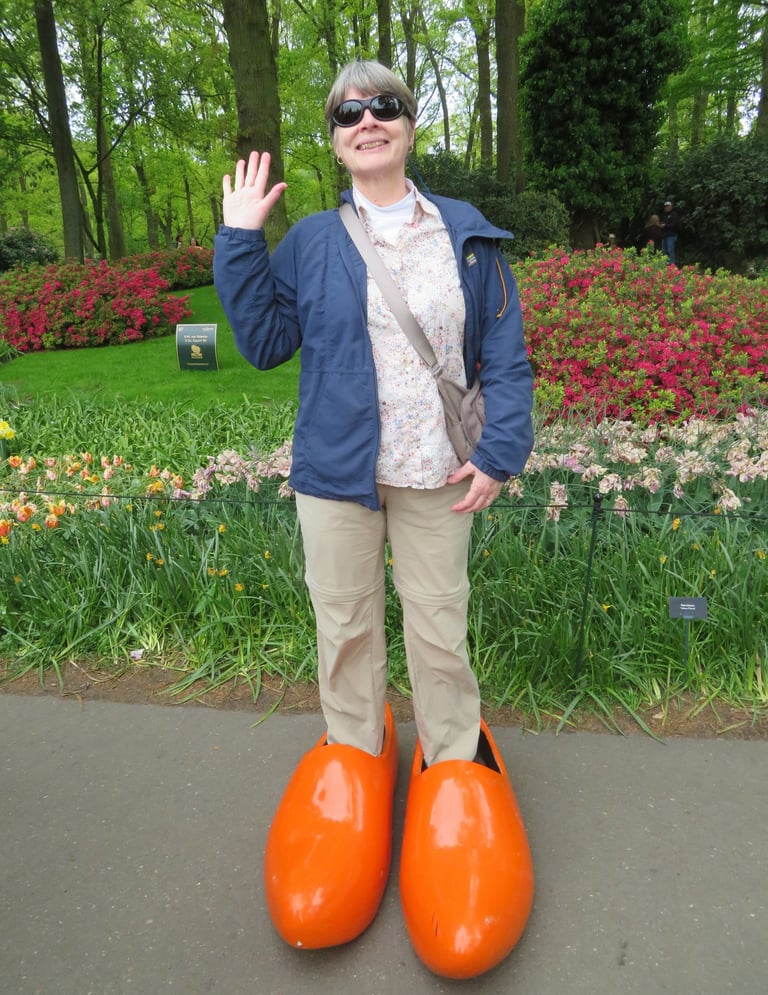 A picture of a woman in large orange wooden shoes.