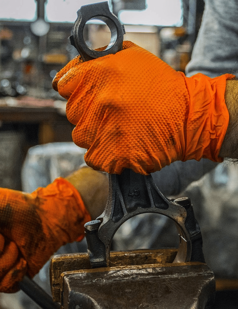 a man in an orange glove holding a wrench