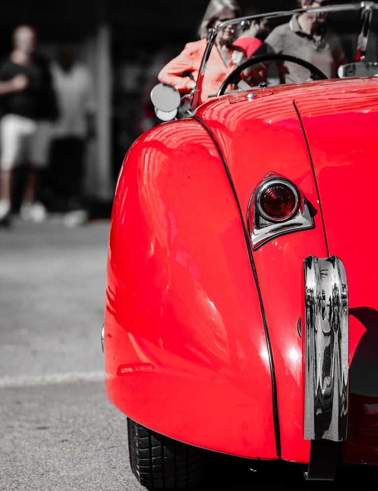 a red Jaguar with a man in a red jacket