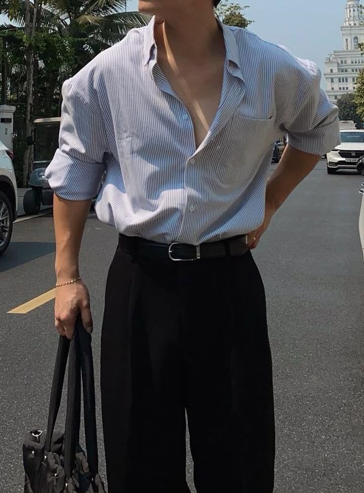 a man in a shirt and pants standing in the street