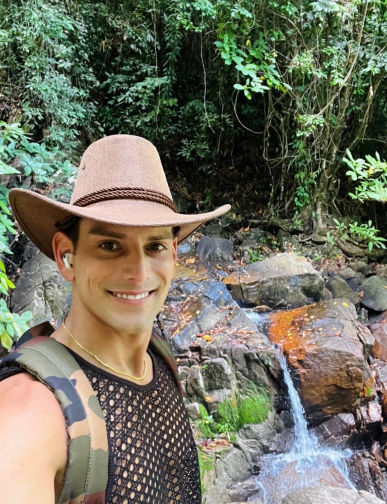 Travel writer Rick Silvia in the jungle in Thailand smiling in front of a small waterfall