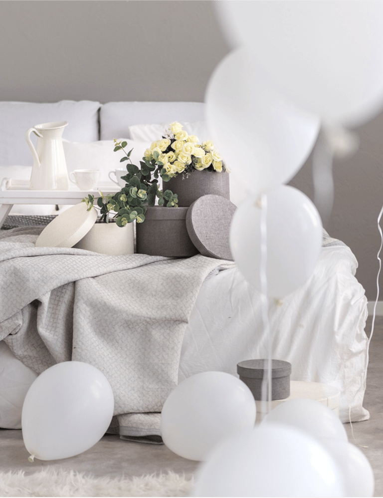 bedroom with subtle hues of linen  with balloons 