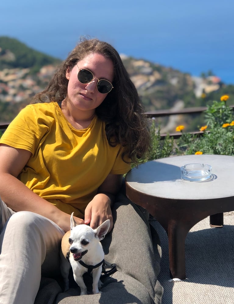 Portrait of Vassianna with her first dog, a chihuahua, sitting outdoors.