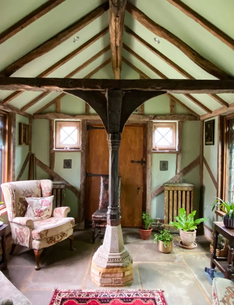 Interior design of an antique room with plaster walls, wooden beams and antique furniture 