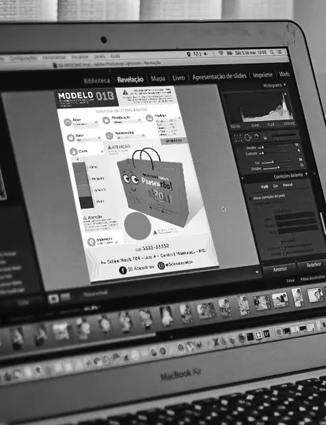 Um computador portátil sobre uma mesa, exibindo um protótipo de um saco de papel.