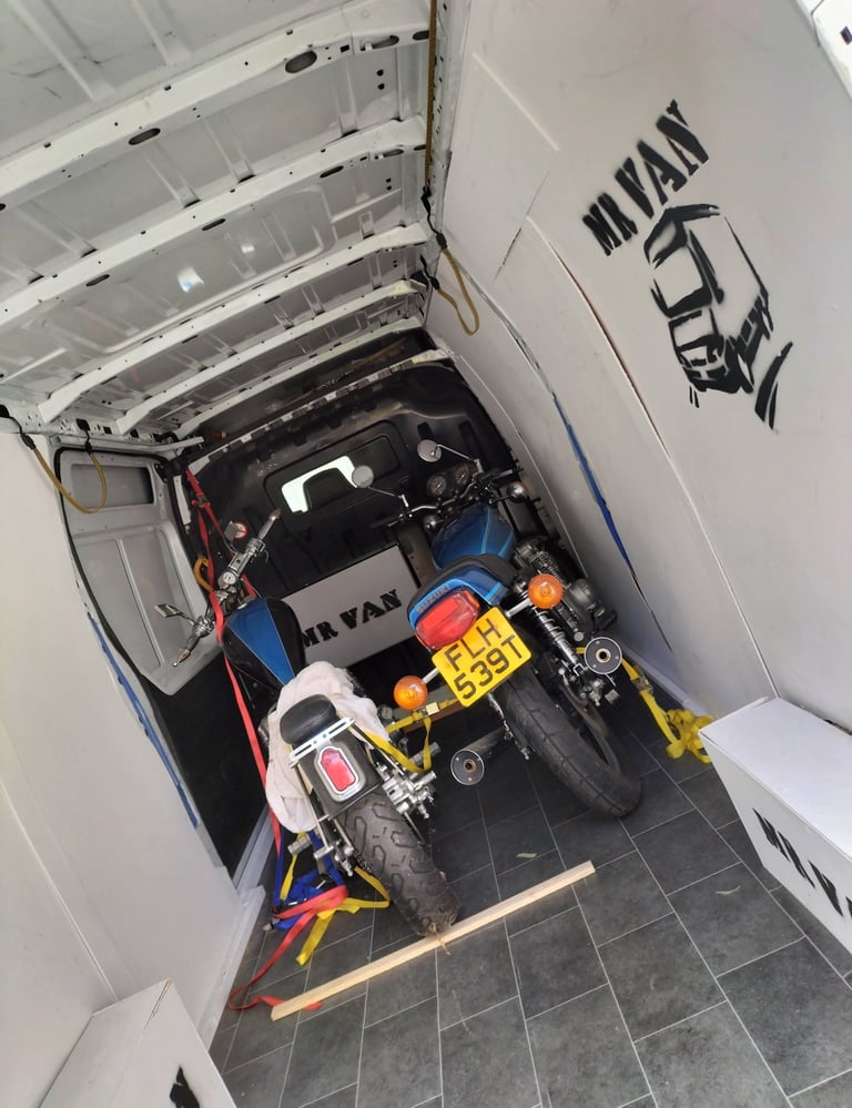 two motorbikes in the back of a van