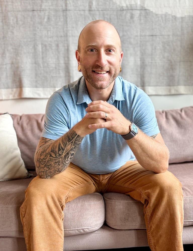 Harrison Blum sitting on coach smiling