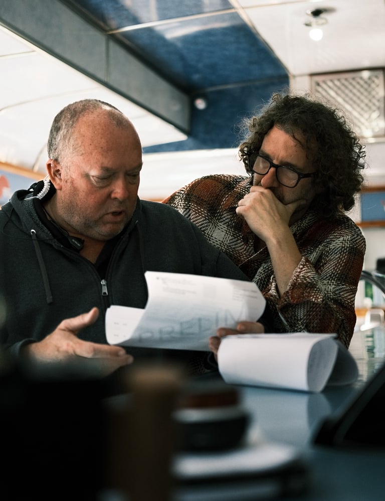 Men sitting at a table, involved in film pre-production discussions