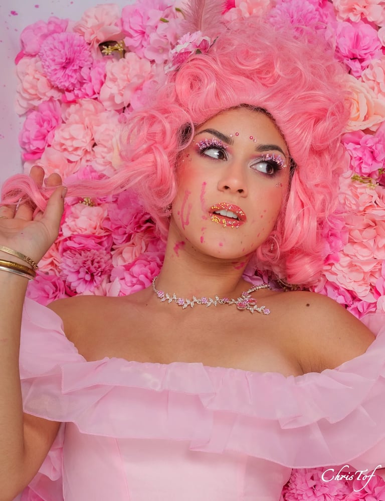 shooting femme avec une perruque rose et une robe assortie sur un fond de rose à Perpignan